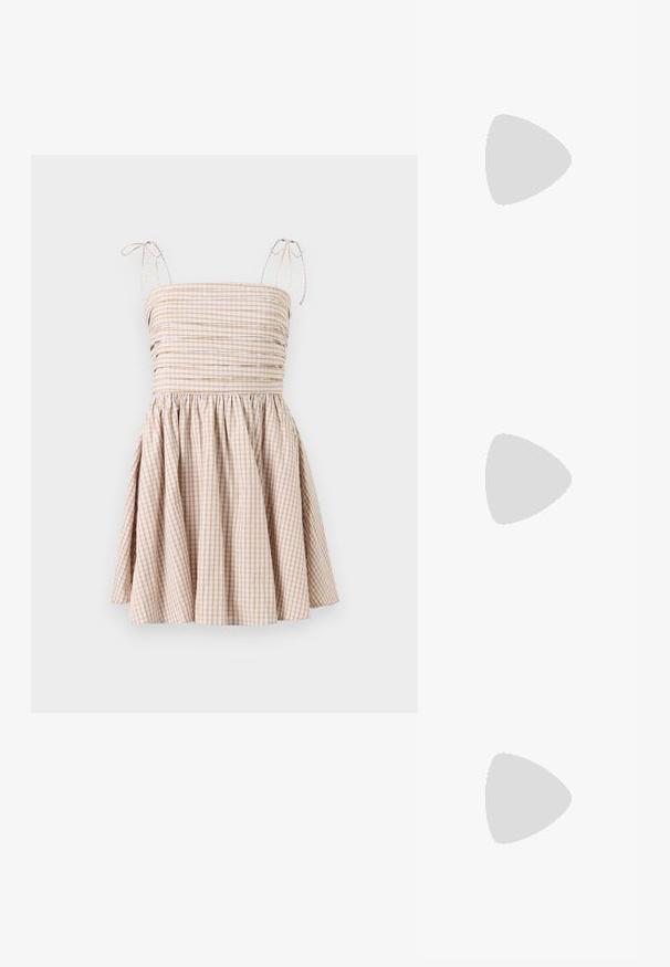 Gingham jurk in beige en wit, met een smock-bodice, verstelbare strikbandjes en een uitlopende rok.; Muntgroene sweatshirt, denim shorts en olijfgroene instappers. Zittend op een lichtgekleurde ladekast tegen een gestructureerde grijze muur.; Zwarte oversized zonnebril met ovale lenzen, een glad plastic montuur en gouden accenten op de pootjes. Donkere lenzen bieden bescherming tegen de zon.; Gouden vierkante polshorloge met een groen verloopdial, gouden uurmarkers en een mesh armband. Merkennaam "CLUSE" weergegeven op de wijzerplaat.