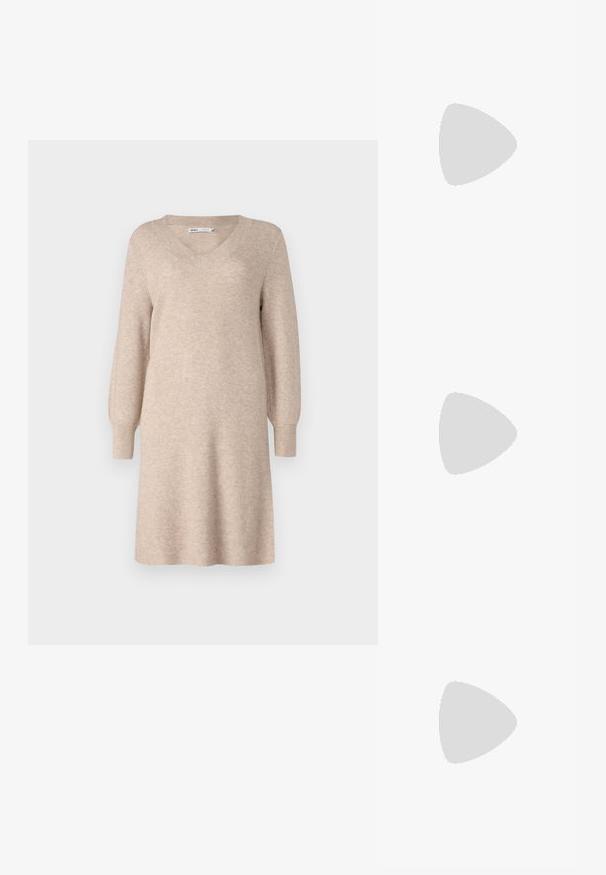 Beige kötött pulóverruha V-alakú nyakkivágással, hosszú puff ujjakkal és laza szabással. Puha anyagból készült, bordázott textúrával.; Fekete, hegyes orrú, magas sarkú cipő, texturált felsőrésszel. Belsejében élénk rózsaszín bélés található. Négyzet alakú sarok, alján fémes díszítéssel.; Fekete kézi táska strukturált formával, sima textúrával és fémből készült záródással. Széles fekete nadrággal és nyitott orrú szandállal párosítva, fából készült padlón.; Ez egy ezüst fülbevaló, sima felülettel, amelyen apró arany díszítőelemek találhatók. Kerek formájú  és a fülcimpán viselik.