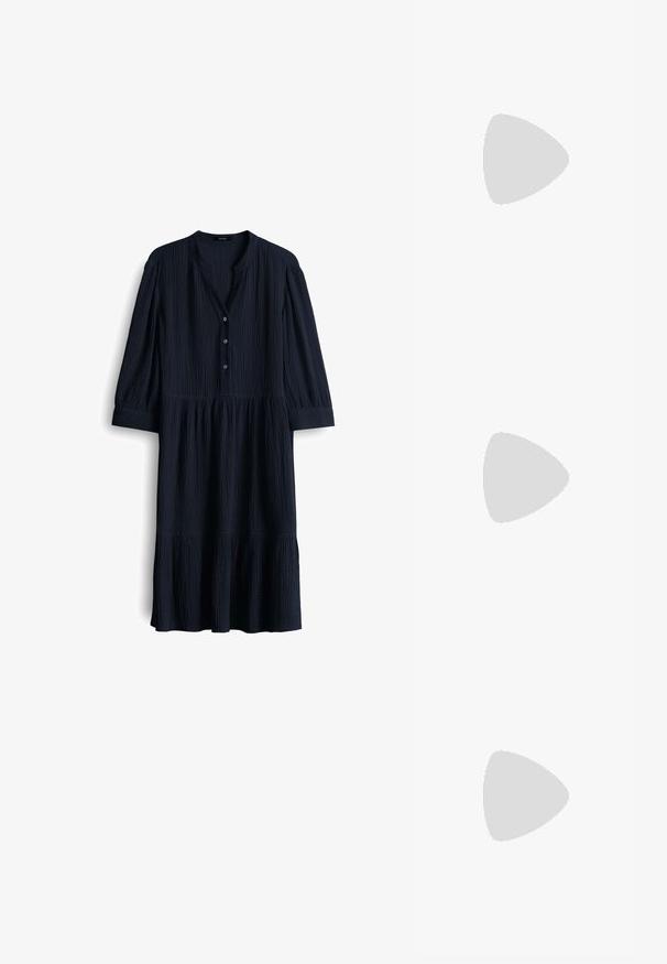 Abito in cotone blu navy, testurizzato, con scollatura a V, tre bottoni e maniche a tre quarti. Orlo svasato con dettagli arricciati.; Sandali con tacco in vernice nera, con punta squadrata, cinturini alla caviglia e fibbie in argento. Presentano un tacco a blocco spesso per maggiore stabilità.; Occhiali da vista in metallo dorato con lenti ovali, bracci sottili e nasalini trasparenti. Presentano sottili dettagli sulle cerniere e lenti trasparenti.; Borsa a tracolla nera in pelle con una forma curva, manico rimovibile e accessori dorati. La borsa presenta una patta con un dettaglio a fibbia.
