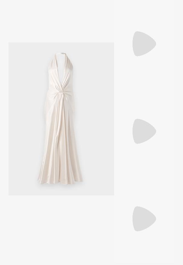Vestido comprido em tecido de seda marfim com alças halter, decote em V profundo e detalhe frontal torcido, apresentando uma saia fluida e textura suave.; Sandal de salto alto prateado metálico com biqueira aberta, apresentando três tiras finas sobre o pé e uma tira no tornozelo com fivela.; Bolsa de mão metálica dourada com uma textura suave, apresentando um fecho em aba triangular. A mão que a segura tem unhas bem cuidadas.; Brinco de argola prateada com acabamento polido, apresentando pequenos detalhes em dourado e uma forma redonda, usado na orelha.