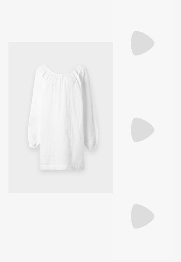 Bela bluzica z dolgimi rokavi iz teksturirane tkanine, z nabranimi detajli ob izrezu in elastičnimi manšetami. Ravna spodnja mera.; Črne gležnjarje iz gladkega usnja, z izostrenim nosom, blokastim peto in izrazitim povišanim šivom na zgornjem robu.; Rjave osmerokotne sončne naočale s prozornim amber okvirjem in rjavimi lečami s senco. Imajo kovinski detajl na mostu in vitke temple.; Rjava nubuk torba za ramena z dvema ročajema, z loputo na gumb in sproščenim, rahlo ohlapnim oblikovanjem.