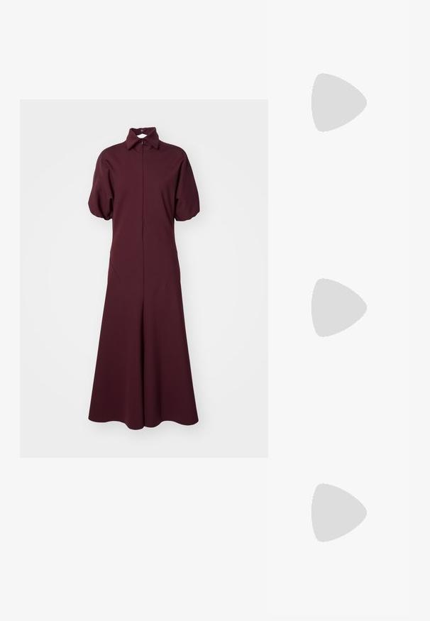 Rochie lungă burgundy cu guler, mâneci scurte tip volănaș și fustă amplă. Realizată dintr-un material neted cu un ușor luciu.; Tory Burch ELEANOR  - Sandale cu baretă între degete - caramel corn/gold; Tory Burch ROMY PEBBLED SATCHEL - Geantă de mână - tiramisu; Cercei cu piatra aurie, de forma circulară, înconjurați de mici pietre clare. Păr ondulat, de culoare roșcat-maro, și o ten fin cu pistrui.