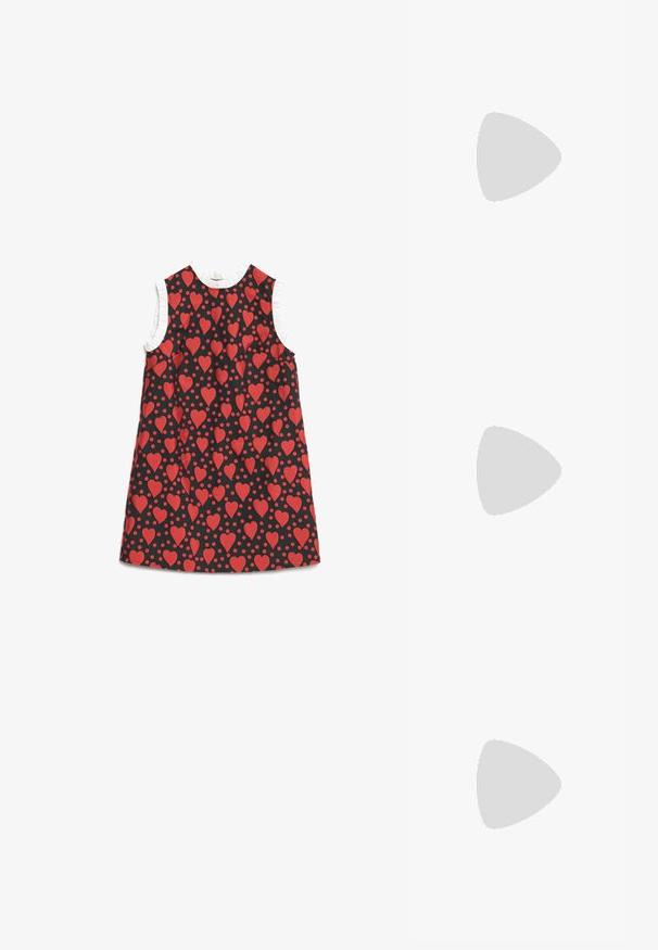 Ermeløs svart kjole med rødt hjerte- og prikkemønster, med hvit volangkant rundt armhullene og halslinningen.; Svarte patent lær slingback hæler med spiss tå og en liten blokkheel, med en sølvspenne som detalj på stroppen.; Svart lærveske med en buet form, avtagbar stropp og gullbeslag. Vesken har et klaff med spenne-detall.; Fire par med sølvøredobber: to blanke glatte hoop-design, ett med tekstur og ett dekket med små klare rhinestones.