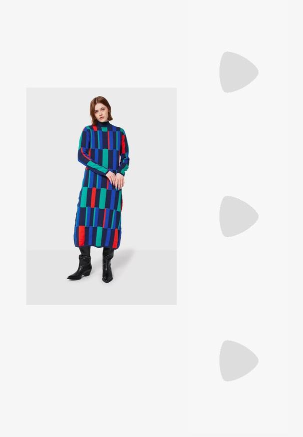 Mujer que lleva un vestido largo de estampado geométrico multicolor con rayas verticales en azul, verde, rojo y negro, combinado con botas negras.; Camiseta de algodón blanca con manga corta y escote redondo. Presenta un logo negro de Adidas en el pecho y un cuello interior negro en contraste.; Top corto verde con ribete blanco, combinado con pantalones de pierna ancha color crema. La modelo sostiene un pequeño bolso negro. Zapatillas deportivas sencillas.; Bolso cruzado negro hecho de material sintético texturizado. Presenta un diseño de logo en relieve y correa ajustable. Cierre con cremallera.