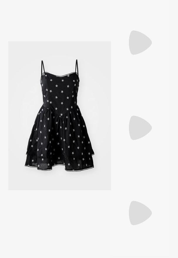 Vestido de algodão preto com bordado floral branco, alças finas, saia rodada e acabamento em ponta ao longo da barra.; Saltos altos pretos com bico fino e atilho ajustável no tornozelo. Confeccionados em couro suave, apresentam um salto bloco robusto.; Bolsa tote preta em couro com textura lisa, forma retangular e duas alças longas. Sem hardware ou enfeites visíveis.; Conjunto de brincos em tom dourado composto por três pares: brincos de botão ovais texturizados, brincos de design ondulado e grandes brincos em argola com camadas em relevo.