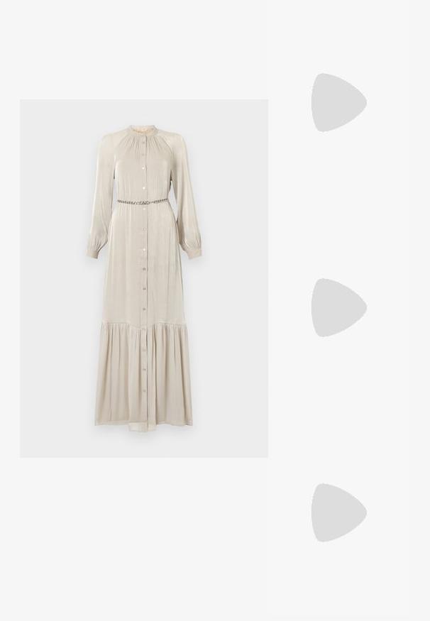Robe longue beige en tissu brillant, avec un devant à boutons, des manches longues, un col froncé et un ourlet à volants. Inclut une ceinture métallique.; Escarpin slingback en vernis noir avec un bout pointu, présentant un imprimé serpent texturé, une sangle réglable et un petit talon bloc texturé.; Sac en cuir noir porté en travers avec deux poches avant, boucles dorées, fermeture zippée et une sangle fine. Surface texturée et forme rectangulaire compacte.; Boucles d'oreilles en métal doré en forme d'anneau, avec une forme courbée et allongée. Elles présentent une surface lisse et brillante avec une pointe arrondie pour un détail supplémentaire.