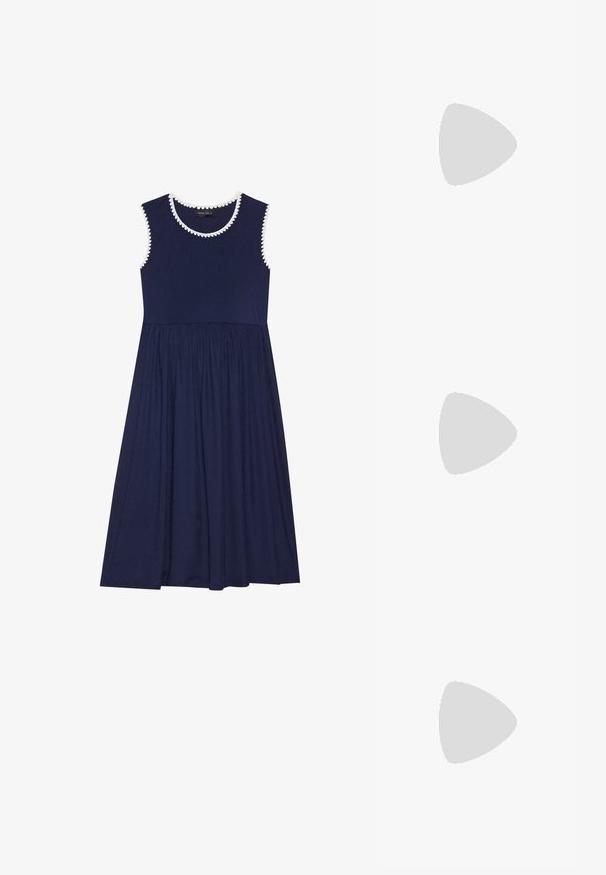 Mornarska brezrokavnik obleka z teksturirano bodico in razprostranjenim krilom, ki ima belo valovito obrobo ob izrezu in odprtinah za roke.; Bela slingback peta z ostrim nosom, gladka zgornja prevleka, nizka blok peta in zasnova z stranskimi izrezi ter nastavljivim trakom z zaponko.; Okrogle sončna očala s temnimi lečami in zlatimi okvirji. Model nosi svetlo modro, rebrasto jakno s gumbi in belimi rokavi v kontrastni barvi.; Michael Kors denarnica v bež lakiranem platnu z mišičnim vzorcem ponavljajočega se logotipa MK, z zlatim okovjem in snemljivo verižico.