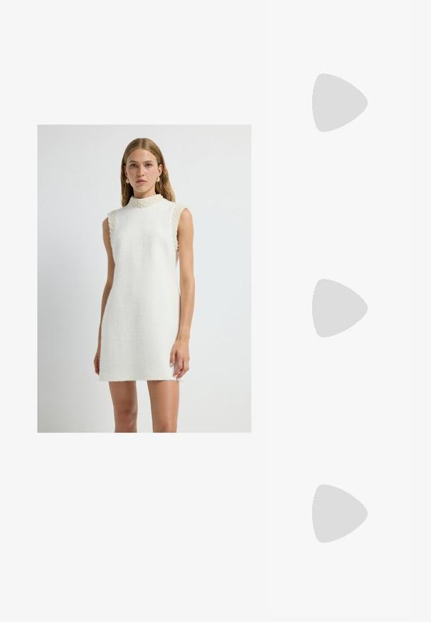 Ärmelloses weißes Kleid aus strukturiertem Stoff mit hohem Kragen, das mit Perlenakzenten an den Schultern und einer geraden Silhouette versehen ist.; Beige Lackleder Slingback-Pumps mit spitzem Vorderteil und einem schlanken, quadratischen Absatz. Glatte Textur und minimalistisches Design ohne Verzierungen.; Weiße strukturierte Handtasche mit kurzen Griffen und einem Schultergurt, ausgestattet mit goldfarbenen Hardware-Elementen und strukturiertem Material, vor einem grauen Hintergrund präsentiert.; Silberner Doppelring mit einer glatten, polierten Oberfläche. Verfügt über ein fließendes, kurviges Design mit überlappenden Abschnitten für einen modernen Look.