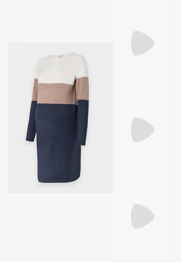 Vestido de malha com mangas longas, apresentando um design em blocos de cor em creme, taupe e azul-marinho. Textura suave e decote arredondado.; Sapatilha branca feita de material sintético liso, com bico arredondado, design de atacador, sola plana e detalhes perfurados subtis.; Óculos de sol oversized pretos com lentes degradê, armações grossas e detalhes em corrente dourada nas hastes.; Bolsa preta com forma estruturada, textura suave e um fecho metálico. Combinada com calças largas pretas e sandálias de salto aberto sobre um chão de madeira.