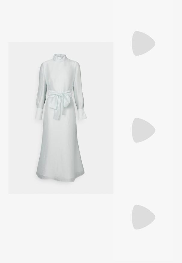 Világoskék, hosszú ujjú ruha magas gallérral, testhez simuló derékkal, melyet masnival kötöttek meg, és sima, fényes anyagtextúrával.; Fekete, hegyes orrú, slingback cipő alacsony sarkával, sima bőrből készült, oldalt kivágott deisgnal a légáteresztőképesség érdekében.; Fekete bőr válltáska puha tapintással, háromszög alakú, állítható pánttal, világoskék csíkos inggel és fehér nadrággal párosítva.; Három fémgyűrű: az egyik rose gold, a másik texturált akcentusokkal ellátott arany, a harmadik pedig ezüst, mindegyiken gravírozott márkajelzés található a belső sávon.