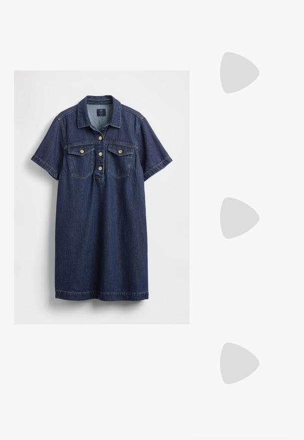 Abito camicia in denim blu scuro con maniche corte, due tasche sul petto, cinque bottoni sulla patta e una texture leggermente slavata.; Top in tessuto a coste bianco senza maniche con scritta metallica dorata che dice "Cowgirl" sul petto, esposto su uno sfondo neutro.; Scarpe nere in pelle verniciata con punta affilata, tacco a blocco e cinturino alla caviglia, abbinate a scaldamuscoli grigi a coste e una gonna in suede marrone.; Top crop a coste grigio e gonna a vita alta verde oliva. Il modello tiene una borsa a spalla bianca con dettagli intagliati. Design semplice, silhouette aderente.