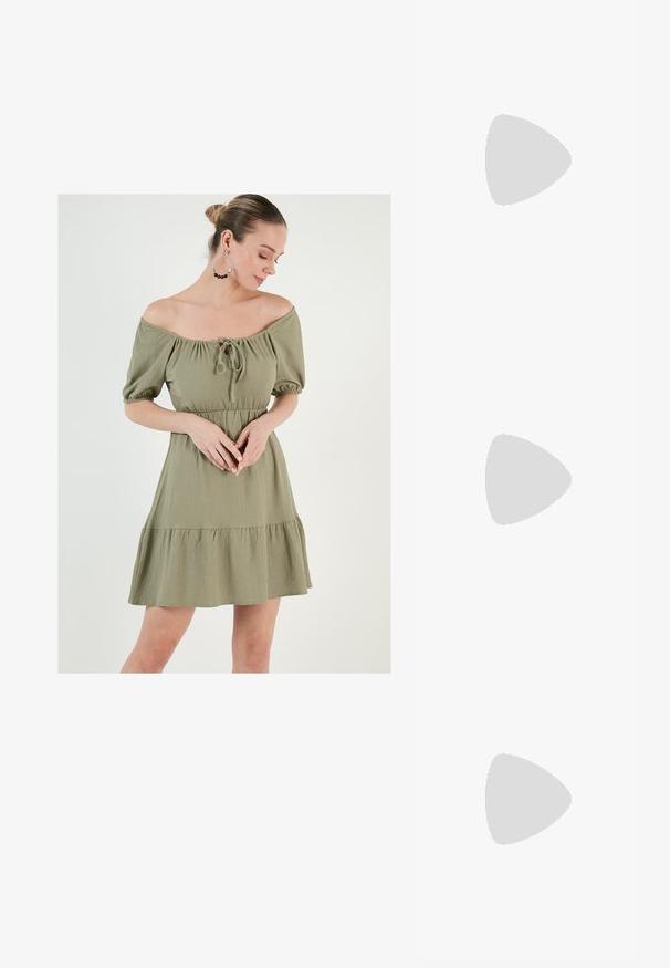 Obleka off-shoulder v olivno zeleni barvi s pufastimi rokavi, cinčanim pasom in volanastim robom. Ima detajl z vezavo na vratu in teksturirano tkanino.; Bela slingback peta z ostrim nosom, gladka zgornja prevleka, nizka blok peta in zasnova z stranskimi izrezi ter nastavljivim trakom z zaponko.; Okrogle sončna očala s temnimi lečami in zlatimi okvirji. Model nosi svetlo modro, rebrasto jakno s gumbi in belimi rokavi v kontrastni barvi.; Michael Kors denarnica v bež lakiranem platnu z mišičnim vzorcem ponavljajočega se logotipa MK, z zlatim okovjem in snemljivo verižico.
