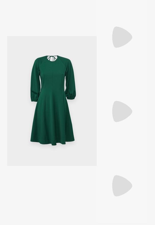 Rochie verde cu mâneci lungi și voluminoase, decolteu rotund și bust strâmt. Fabricată dintr-un material moale, aceasta se lărgește ușor la talie până la tiv.; Pantofii cu toc înalt din piele neagră, cu vârf ascuțit și toc rotund, mimos. Textură netedă, cu un design elegant și minimalist.; Geantă din piele neagră cu o formă curbată de lună, având o curea subțire și un branding subtil aurit pe față. Textură netedă cu hardware minimal.; Cerceii cu nuanță de aur prezintă forme neregulate texturate, împodobiți cu pietre prețioase verzi și perle albe, asigurați cu prinderi tip clip.
