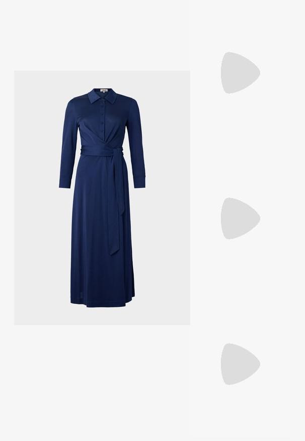 Tummansinisessä mekossa on kaulus, pitkät hihat, napitettu etuosa ja vyötäröremmi. Mekko on muotoiltu kietaisumalliksi ja siinä on sileä pinta. Pituus ulottuu polven keskivaiheille.; Valkoiset nahkakengät, matala malli, jossa on sileä pinta, pyöreä kärki, nauhakiinnitys edessä ja pieni brodeerattu logo sivulla.; Mustelman mustahuulikoobas koos kuldsete detailidega, millel on lukk. Kandmisel üle keha halli kampsuni peal.; Kultaketjut korvakorut, joissa on kierretystä muotoilusta valmistettu solmu. Jokaisessa korvassa on pyöreä, kirkas tausta varman käyttömukavuuden takaamiseksi.