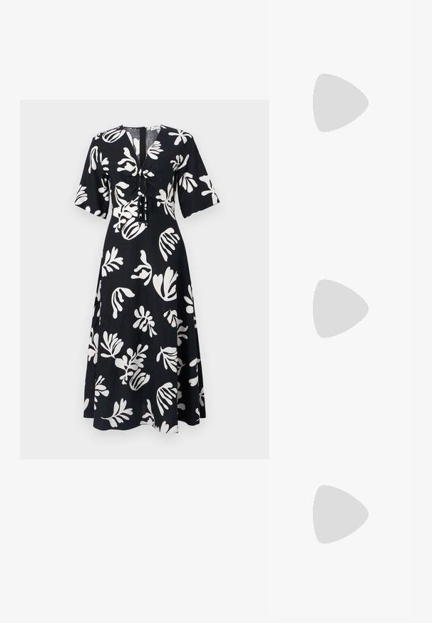 Schwarzes Kleid mit weißem Blumenmuster, mit kurzen Ärmeln, V-Ausschnitt und Kordelzugdetails an der Vorderseite. A-Linien-Silhouette.; Schwarze Leder-Ballettschuhe mit abgerundeter Spitze, glatter Textur, minimalen Nähdetails und einem flexiblen Sohlen-Design.; Schwarze Leder-Halbmondtasche mit einem goldenen Hardware-Akzent und einem Reißverschluss. Über einem grauen Pullover quer über den Körper getragen.; Goldfarbene Ohrstecker mit Knoten in gedrehter Ausführung. Jeder Ohrstecker verfügt über eine runde, transparente Rückseite für sicheren Halt.