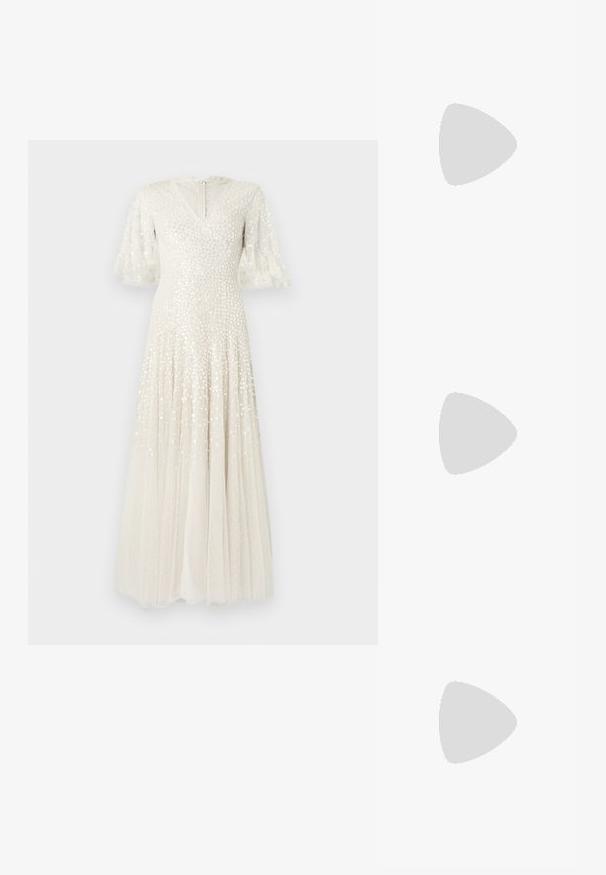Witte maxi-jurk met een V-hals, uitlopende doorschijnende mouwen, versierd met pailletten en een vloeiende, geplooide rok. Sluiting met ritssluiting aan de achterkant.; Witte leren sneakers, laag model, met een gladde textuur, ronde neus, vetersluiting aan de voorkant en een klein geborduurd logo aan de zijkant.; Zwarte leren halfronde tas met een gouden hardware accent, voorzien van een ritssluiting. Draagt crossbody over een grijze trui.; Gouden knoopstuds met een gedraaide design. Elke oorring heeft een ronde transparante achterkant voor een veilige draagervaring.