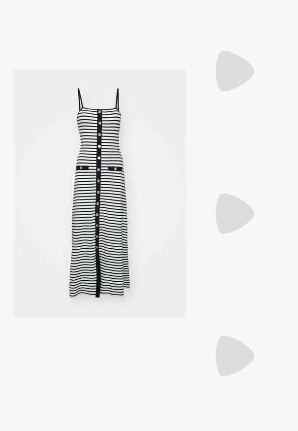 Robe midi rayée en noir et blanc avec des bretelles fines, des boutons dorés sur le devant et deux poches avant bordées de noir.; Ballerine en cuir verni noir avec un bout carré, sangle de cheville avec des détails en métal argenté et semelle plate. Texture lisse avec un design minimaliste.; Sac à main en cuir noir avec des détails en franges, chaîne dorée pour l'épaule et une poignée découpée. Présente le logo sur le devant.; Boucles d'oreilles en ton or avec plusieurs chaînes en cascade, présentant des accents en strass ovales transparents et des dessus à clous décoratifs.