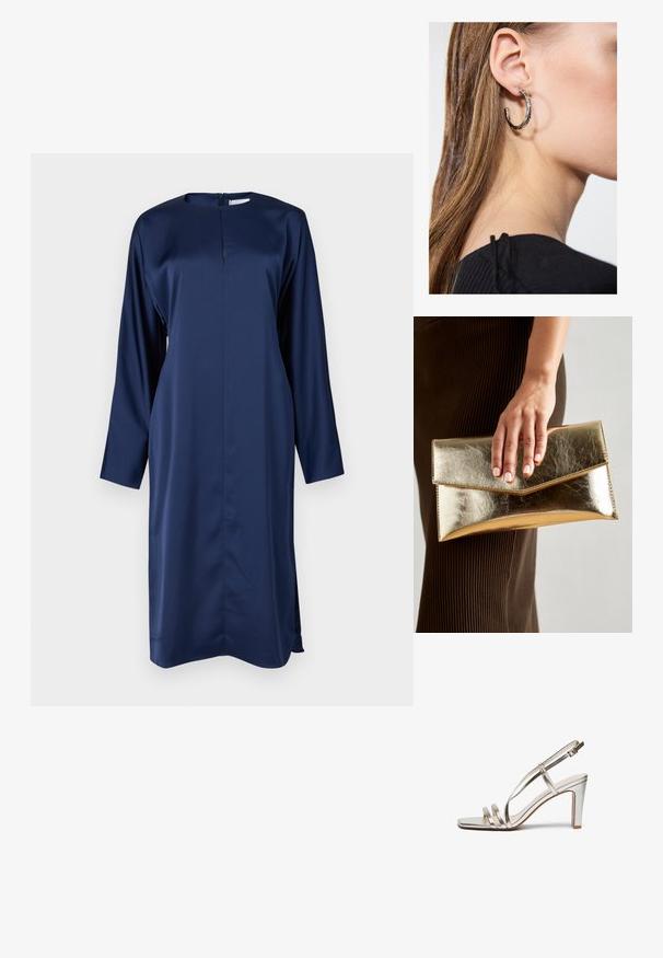 Svečana haljina tamnoplave boje od satena, s dugim rukavima, visokim ovratnikom i patentnim zatvaračem na leđima. Ima bočne proreze za lakše kretanje i elegantan, upečatljiv kroj.; Metalni srebrni sandali s visokom petom i otvorenom prstima, sa tri tanke trake preko stopala i trakom za gležanj sa kopčom.; Zlatna metalik torbica s glatkom teksturom, s trokutastim zatvaranjem na preklop. Ruka koja je drži ima uredno nj njegovane nokte.; Srebrna kružna naušnica s poliranim završetkom, koja ima male zlatne detalje i okrugli oblik, nošena na uhu.