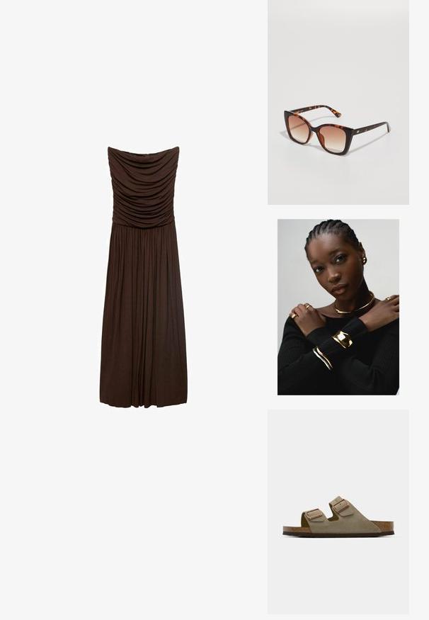 Hnedé šaty bez ramienok s nahrnutým materiálom na korzete, s voľnými záhybmi na sukni, vyrobené z mäkkého a ľahkého materiálu.; Svetlo taupe semišové sandále s dvoma nastaviteľnými pásikmi a ružovým zlatom. Korková stielka na textúrovanej hnedej podrážke. Dizajn s otvorenou špičkou.; Želvovinové slnečné okuliare s prehnanými štvorcovými šošovkami, prechodovým hnedým zafarbením a elegantnými, lesklými ramenami s jemnými kovovými akcentami.; Zlaté šperky zahŕňajú choker, viaceré prstene a náramky s hladkými a textúrovanými povrchmi, položené na tmavom žebrovanom svetri.