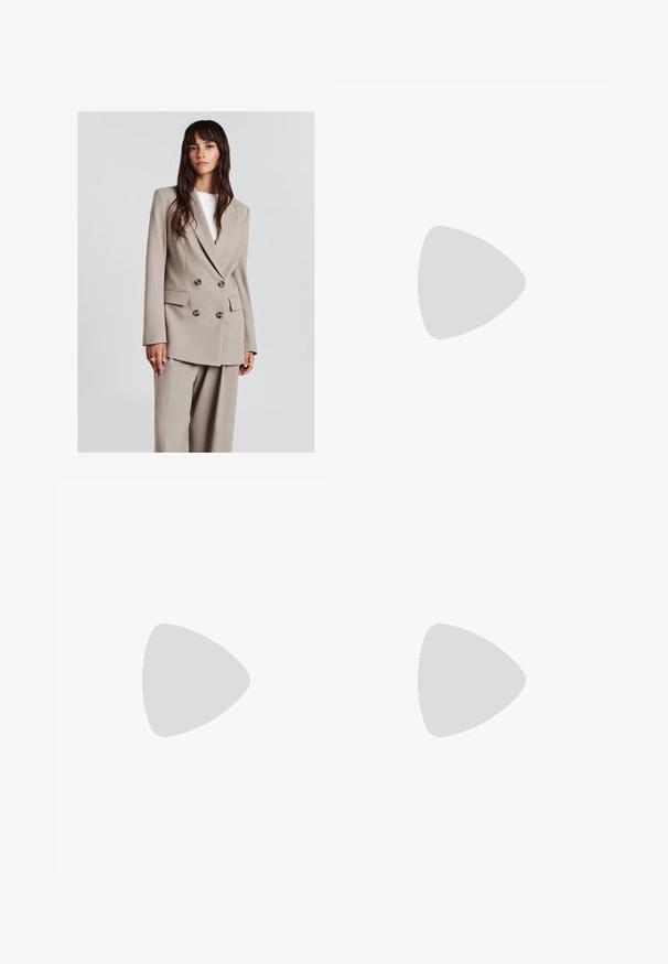 Giovane donna con lunghi capelli castani indossa un blazer beige doppiopetto e pantaloni larghi abbinati, in piedi di fronte a uno sfondo chiaro uniforme.; T-shirt grigio a maniche corte realizzato in tessuto morbido, con scollo a V e una vestibilità rilassata. Presenta una sottile trama e un design semplice.; Jeans a gamba larga di un azzurro chiaro, realizzati in denim, con vita alta, tasche frontali e chiusura con bottone. Texture liscia con zone sbiadite.; Scarpa sportiva bianca con tomaia in mesh, dettagli in blu marino e suola imbottita. Presenta il logo "N", lacci e dettaglio texturizzato sul lato.