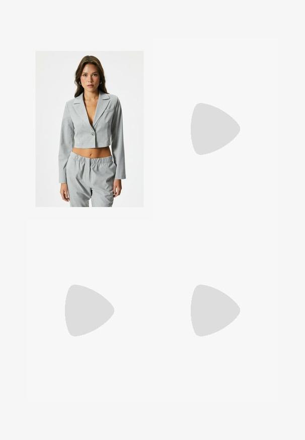 Blazer grigio accorciato con maniche lunghe, rever a punta, chiusura con un bottone e una piccola tasca frontale. Abbinato a pantaloni sagomati coordinati.; Felpa nera con cappuccio caratterizzata da un grande design grafico blu sul davanti, dotata di tasca a marsupio e polsini e orlo a coste.; Pantaloni della tuta grigio chiaro con una vestibilità rilassata, vita elasticizzata, cordoncino e tasche laterali; realizzati in un morbido tessuto testurizzato.; Sneaker bianca con una prominente striscia beige, suola grigia spessa e dettagli dorati. Presenta lacci rotondi e un'etichetta sulla linguetta testurizzata con il logo.