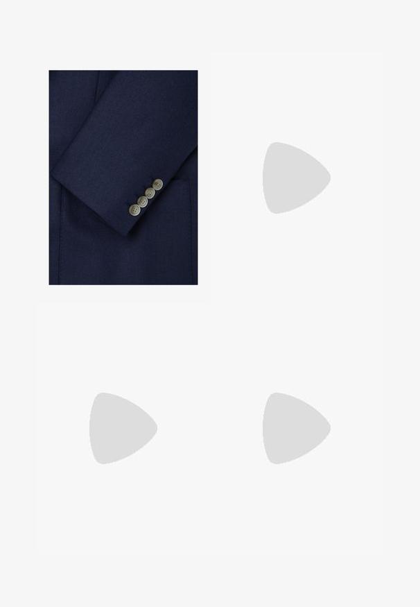Manica di blazer in lana blu navy con finitura texturizzata, caratterizzata da quattro bottoni chiari lungo il polso e cuciture sartoriali.; T-shirt in cotone blu navy con colletto tondo e maniche corte. Presenta un logo Nike bianco sul petto a sinistra e un orlo dritto.; Pantaloni da tuta Nike blu navy realizzati in un morbido misto cotone, con vita elastica, gambe affusolate e un piccolo logo bianco sul lato.; Sneaker bianco in pelle con superfici texture, collo imbottito e ammortizzazione d'aria visibile nella suola. Presenta lacci e un design minimalista.