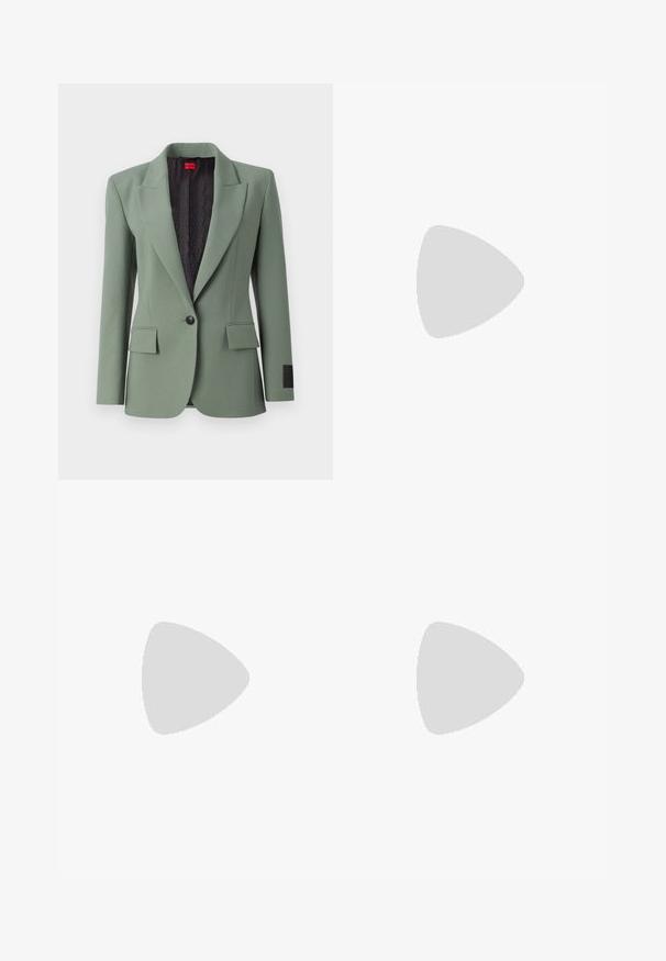 Hele roheline bleiser, mis on valmistatud siledast kangast, notšitud kraega, ühe nupuga kinnitusega, kahe ees oleva taskuga ja mustrilise musta voodriga.; Mustmust särk, millel on ümar kaelus, lühikesed varrukad ja tindiga tikitud logo rinnal. Lihtne, mugav lõige ilma mustriteta.; Mustad ja sirged püksid, millel on sile tekstuur ja teravad voldid esiosas. Ilma nähtavate detailideta.; Mustad nahast slingback kontsad terava ninaga, millel on õhuke konts ja kuldse tooni aktsent reguleeritaval rihmal. Sile tekstuur.