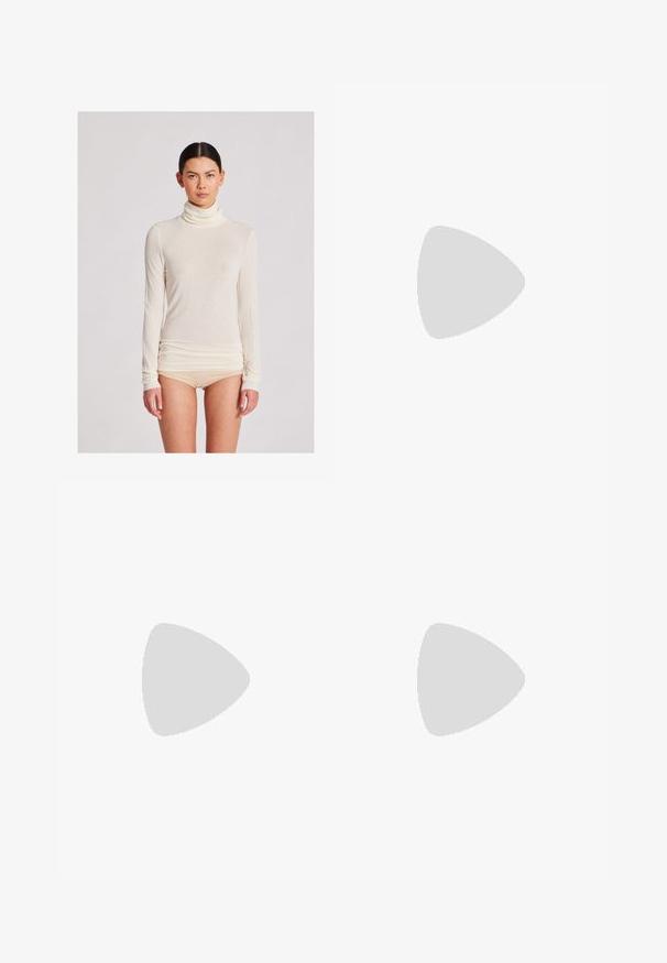 Langärmliges Rollkragenoberteil in Creme, aus leichtem Stoff mit glatter Textur; zeichnet sich durch eine figurbetonte Silhouette und geraffte Saumdetails aus.; Dunkelbraune gerade geschnittene Jeans aus Denim mit einem klassischen Fünf-Taschen-Design, metallischen Beschlägen und sichtbaren Nähdetails.; Schwarz-weiße Kuhflecken-Lederschuhe mit flacher Gummisohle, ausgestattet mit einer glatten Oberfläche und abgerundetem Zehendesign. Verstellbare Riemenakzente im oberen Bereich.; Gewebte Handtasche aus dunkelolivgrünem Leder, mit einem runden Oberhandgriff und einer weichen, strukturierten Oberfläche im Hobo-Stil.; Silberne Creolen mit polierter Oberfläche, die eine kreisförmige Form und einen Schwenkverschluss aufweisen, und dabei ein elegantes und minimalistisches Design betonen.