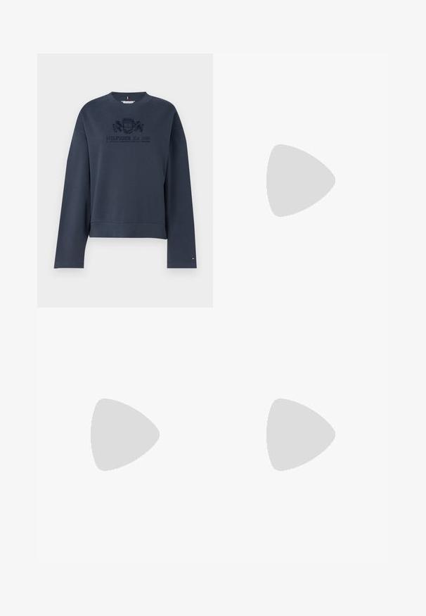 Navy zila džemperis, izgatavots no mīksta auduma, ar apaļu kakla izgriezumu, garām piedurknēm un stiprinātu logotipu centrā.; Platām kājām tumši zili denim džinsi ar augstu jostasvietu. Iespējas klasiskā piecu kabatu dizaina un viegls izbalējums uz gurniem. Metāla pogas aizdare.; Melni ādas loafers ar austu akcentu uz purngala, zelta logotipa detaļu un masīvu melnu gumijas zoli. Gluda tekstūra ar nelielu spīdumu.; Melnas ādas rokassoma ar izliekumu formu, kā arī izšūtu tekstūru un zelta aksesuāriem. Iespējas iekļauj noņemamu plecu siksnu un logo detalizāciju.