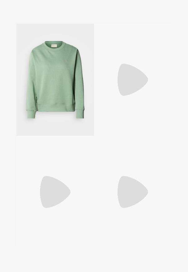 Miętowa bluza z okrągłym dekoltem, długimi rękawami, ściągaczami przy mankietach i u dołu. Posiada małe haftowane logo na piersi.; Bluzka w wzory z motywem paisley w kolorach granatowym, beżowym i jasnoniebieskim, wykonana z lekkiej tkaniny, z krytym zapięciem na guziki i kołnierzykiem.; Ciemnoniebieskie dżinsy szerokie w nogawkach wykonane z denimu, z wysokim stanem, z pomarańczowymi przeszyciami, pięcioma kieszeniami i zapięciem na guzik.; Białe sneakersy typu low-top z czarnym paskiem na pięcie, platformą, sznurowadłami i logo "CK" marki Calvin Klein na boku.