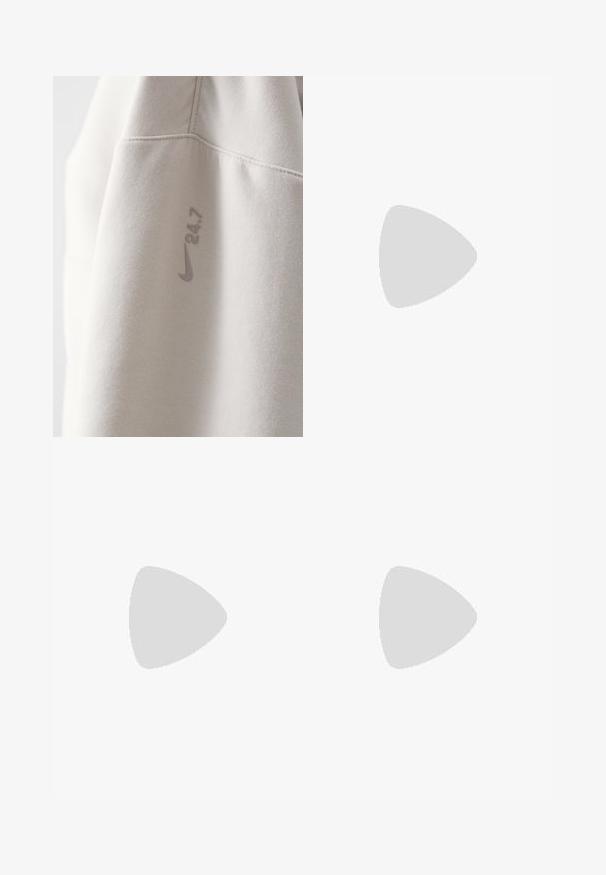 Heled hall hallitus, mis on valmistatud pehmest kangast, ja millel on Nike logo ning trükitud "24.7" veidi tumedamas toonis. Sile tekstuur, minimalistlik disain.; Kerged pruunid chino püksid, sirge lõikega, nööbiga kinni pandud ja küljetaskudega. Kanga pind on sile ja mati viimistlusega.; Valged ja hõbedased Nike tennisajalatsid, millel on võrgukangas, peegeldavad detailid ja beež tald. Kantud mustade sokkidega, seisab sinisel pinnal.; Selged prillid, millel on ristkülikukujuline kuju, klaarsed plastists raami ja sile pind. Nähtavaid logosid või kujundusi pole.