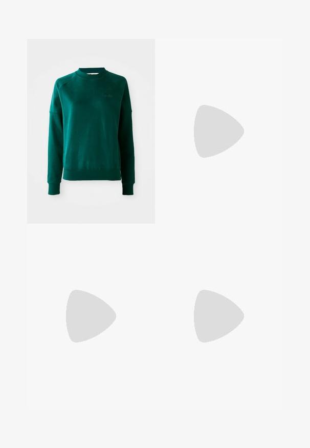Zelená mikina s crewneck výstrihom a raglánovými rukávmi, vyrobená z mäkkej látky. Obsahuje rebrovaný golier a manžety a nenápadné značenie na hrudi.; Svetlo šedé džínsy s uvoľneným strihom, s poškodeným detailovaním a roztrhnutím na kolenách a vyblednutou textúrou. Obsahujú päť vreciek a pútka na opasok.; Športové topánky Nike s strieborným sieťovaným zvrškom, bielymi detailmi a textúrovanými podrážkami, skombinované s voľnými námorníckymi nohavicami.; Strieborné kruhové náušnice s prúteným dizajnom, s lešteným povrchom a zapínaním na kolíček. Majú priemer približne 3 cm.