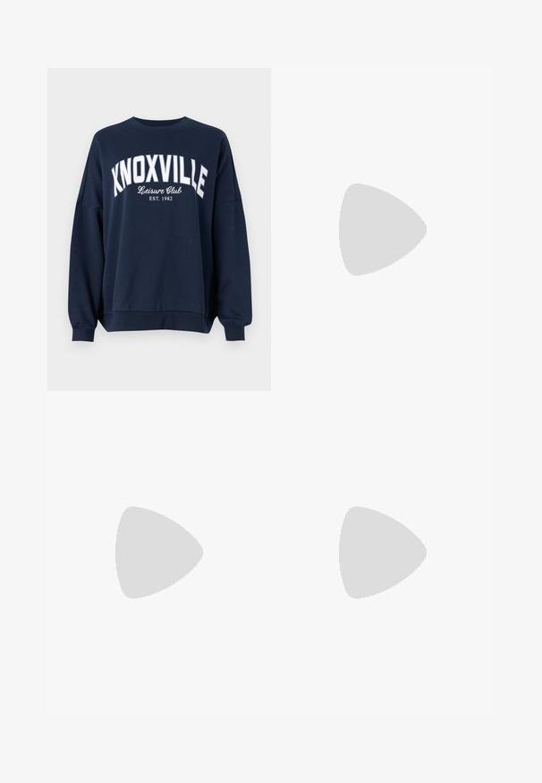 Felpa blu navy con scritta bianca "KNOXVILLE Leisure Club EST. 1982." Presenta un collo tondo e maniche con polsini a coste larghi.; Jeans a gamba larga in denim blu scuro. Presentano cinque tasche, passanti per cintura e un orlo grezzo in fondo con dettagli di cucitura visibili.; Sneaker argento con una tomaia in mesh testurizzato e accenti iridescenti, dotata di una suola bianca spessa e chiusura con lacci.; Borsa a tracolla nera in pelle con una forma curva, manico rimovibile e accessori dorati. La borsa presenta una patta con un dettaglio a fibbia.