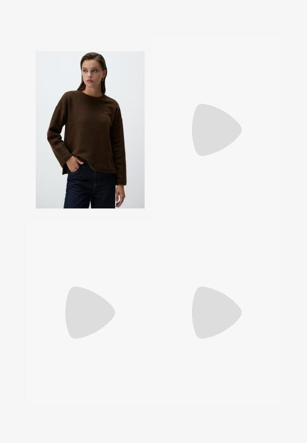 Felpa marrone in pile con colletto rotondo e maniche lunghe, caratterizzata da una vestibilità comoda e spacchi laterali. Abbinata a jeans in denim scuro.; Pantaloni a gamba larga di un leggero colore crema. Realizzati in un tessuto morbido con pieghe sul davanti e tasche laterali.; Décolleté bianco con punta affilata, caratterizzato da una tomaia liscia, sottili aperture e un tacco a blocco basso. La suola nera esalta il design.; Borsa a tracolla in pelle marrone con forma curvata, hardware dorato e un dettaglio con fibbia. Presenta una tracolla rimovibile.