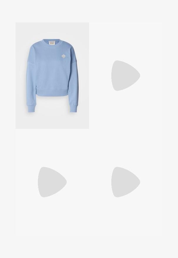 Felpa corta azzurra realizzata in materiale morbido. Presenta un collo tondo, spalle scese e un piccolo design ricamato sul petto.; Jeans in denim blu chiaro a gamba larga. Presentano una vita alta, chiusura con bottone e cuciture in vista. Non sono visibili tasche sul davanti.; Décolletés Mary Jane bianchi in pelle con punta affilata, fibbia laterale e tacco basso nero. Texture liscia e design minimalista.; Borsa a tracolla in pelle nera con due manici lunghi, una texture liscia e una forma strutturata. Presenta una tasca frontale per ulteriore spazio di archiviazione.