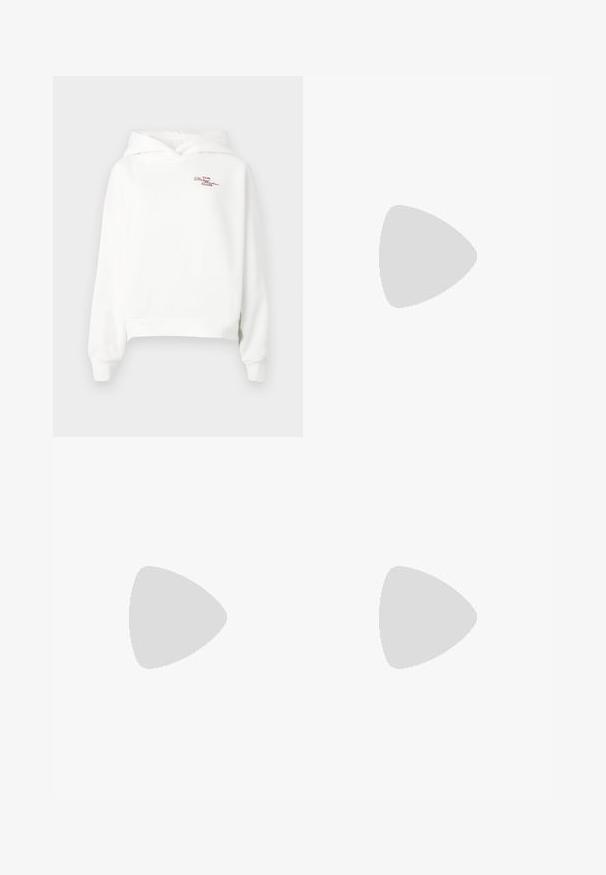 Haut crop blanc en coton doux. Comprend une poche kangourou à l'avant et des poignets côtelés. "LE CLUB Désenchanté" brodé en rouge.; Jean large en denim bleu foncé. Présente des coutures contrastées, cinq poches et une fermeture par bouton à la taille. Texture lisse.; Chaussures plates noires avec un petit nœud au niveau des orteils, associées à des collants côtelés marron foncé. Les chaussures ont une texture lisse et un profil bas.; Pochette rectangulaire blanche en matériau brillant, avec une bandoulière en chaîne argentée. Le modèle pose en mettant en valeur le sac contre un fond uni.