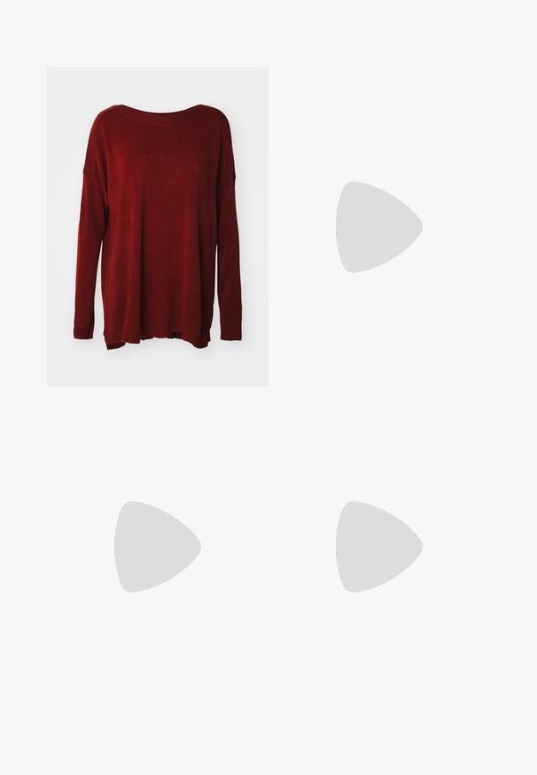 Pull en tricot rouge avec un décolleté large, des manches longues, une coupe décontractée et des poignets côtelés. Texture douce avec un léger effet satiné.; Jeans large en denim bleu clair, à taille haute, avec cinq poches et couture visible le long des coutures.; Baskets blanches en cuir avec une boîte à orteils perforée, semelle texturée et lacets blancs, associées à un large pantalon rouge et un fond bleu et jaune.; Femme avec de longs cheveux foncés portant un costume noir, portant un sac à épaule en cuir noir, regardant par-dessus son épaule contre un fond blanc.