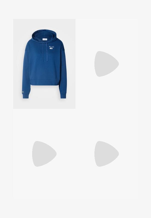 Marineblaue cropped Hoodie aus Baumwolle, mit Kängurutasche, Kapuze mit Zugband und besticktem Logo auf der Brust und dem Ärmel.; Marineblaue weite Hose mit elastischem Bund, zwei Seitentaschen und einer glatten, gewobenen Textur. Keine sichtbaren Muster oder Hardwaredetails.; Schwarzer spitz zulaufender Slingback-Schuh mit niedrigem Absatz, der aus glattem Leder gefertigt ist und seitliche Ausschnitte für Atmungsaktivität aufweist.; Cremfarbener Handtasche mit strukturiertem Finish, gebogener Form, kurzem Griff und Logo-Detail in Gold. Reißverschlussverschluss oben.