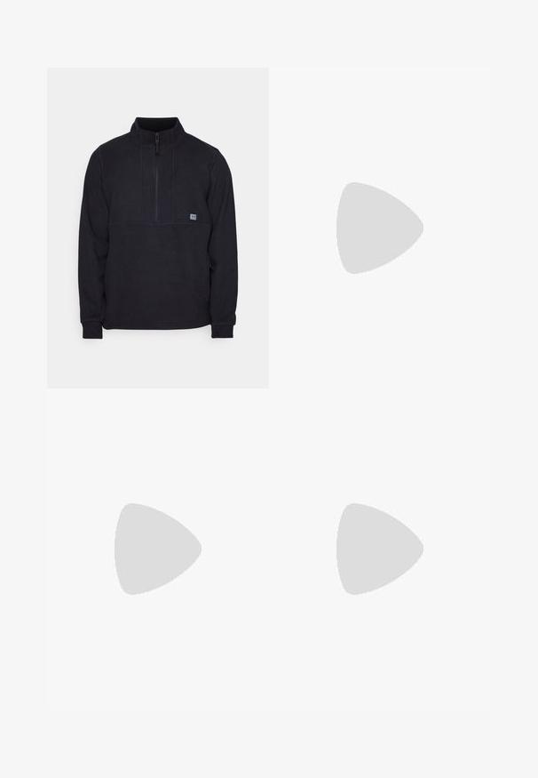 Černý fleecový pulovr s polo zipem, obsahující detail švu na hrudi a malé logo na levé straně. Měkká textura, dlouhé rukávy.; Bílé triko z bavlny s krátkým rukávem, kulatým výstřihem, volným střihem a bez viditelných log či vzorů. Hladká textura a minimalistický design.; Kalhoty s vysokým pasem, volného střihu, vyrobené z vybledlého černého denimu. Mají pět kapes, poutka na opasek a čistý, rovný střih nohavic.; Bílé kožené tenisky s texturovaným černým Swooshem, plochými tkaničkami a gumovou podrážkou s drážkovaným vzorem. Na patě je embosováno "AIR".