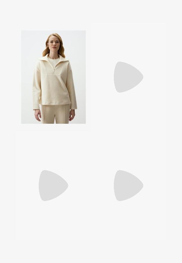 Light cream pullover made of textured fabric, featuring a high collar, zipper, and loose fit. Paired with beige fitted pants.; Black trousers with a straight fit, featuring front pockets and side slits at the hem. Made of soft, smooth fabric. Suitable for various occasions.; Black patent heeled sandals with a square toe, ankle straps, and silver buckles. Features a chunky block heel for stability.; Black leather handbag with a curved shape, detachable strap, and gold hardware. The bag features a flap with a buckle detail.