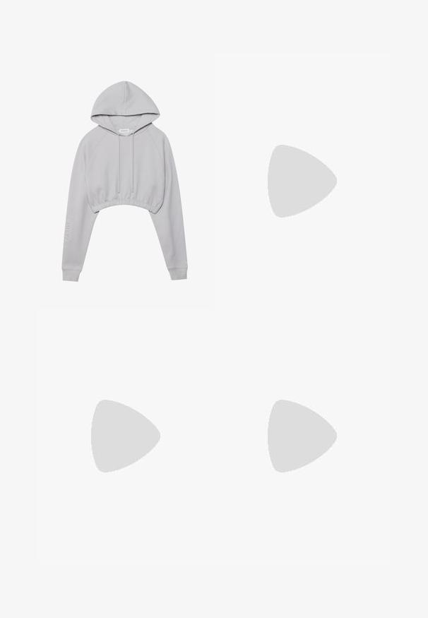 Haut à capuche gris court avec cordon de serrage, manches raglan et ourlet élastique. Présente le texte "ACTIVE" sur la manche gauche. Texture de tissu douce.; Pantalons évasés gris en tissu texturé, dotés d'une fermeture à deux boutons et de passants de ceinture, associés à des baskets argentées brillantes.; Botte noire à la cheville en cuir lisse. Possède un bout carré, un haut élastiqué et un talon épais pour la stabilité. Design minimaliste.; Sac à main en cuir verni noir avec une texture crocodile, quincaillerie dorée, une poignée supérieure et une bandoulière amovible. Forme rectangulaire avec une fermeture à rabat.