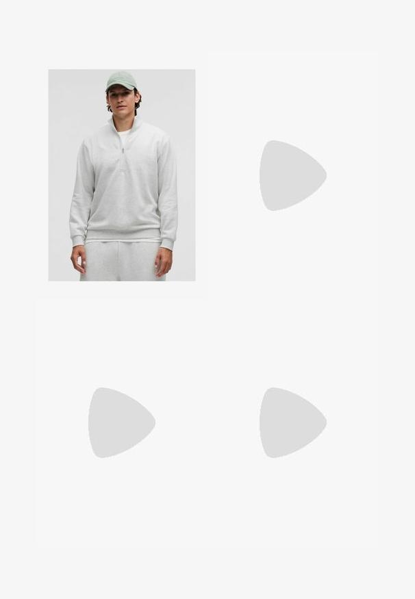 Hellgrauer Reißverschluss-Pullover mit langen Ärmeln, weichem Material und gerippten Bündchen. Wird über einem weißen Shirt getragen und mit passenden Hosen kombiniert.; Weißes kurzärmliges Hemd aus strukturiertem Stoff. Verfügt über einen kragenlosen Ausschnitt und Knöpfe auf der Vorderseite. Einfaches, sauberes Design.; Hellblaue Denim-Jeans mit geradem Schnitt, Fünf-Taschen-Design und einem sichtbaren Markenlabel am Bund.; Weiße Sneaker mit einem glatten Lederoberteil, flachen Schnürsenkeln und einer dicken Gummisohle. Das minimalistische Design verfügt über subtile Nähte und nahtlose Akzente.