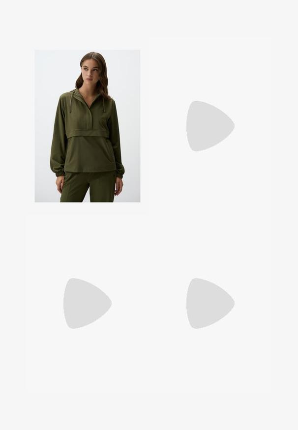 Zielona oliwkowa bluza z kapturem, zapinana na pół zamek z przodu, z elastycznymi mankietami. Posiada poziomą szew na wysokości klatki piersiowej oraz boczne kieszenie.; Czarne spodnie o prostym kroju, z przednimi kieszeniami i bocznymi rozcięciami na dole. Wykonane z miękkiego, gładkiego materiału. Odpowiednie na różne okazje.; Czarne lakierowane sandały na obcasie z kwadratowym noskiem, z paskami wokół kostki i srebrnymi klamrami. Posiadają masywny słupek dla stabilności.; Czarna skórzana torba tote o gładkiej fakturze, prostokątnym kształcie i dwóch długich uchwytach. Brak widocznych elementów metalowych i ozdób.