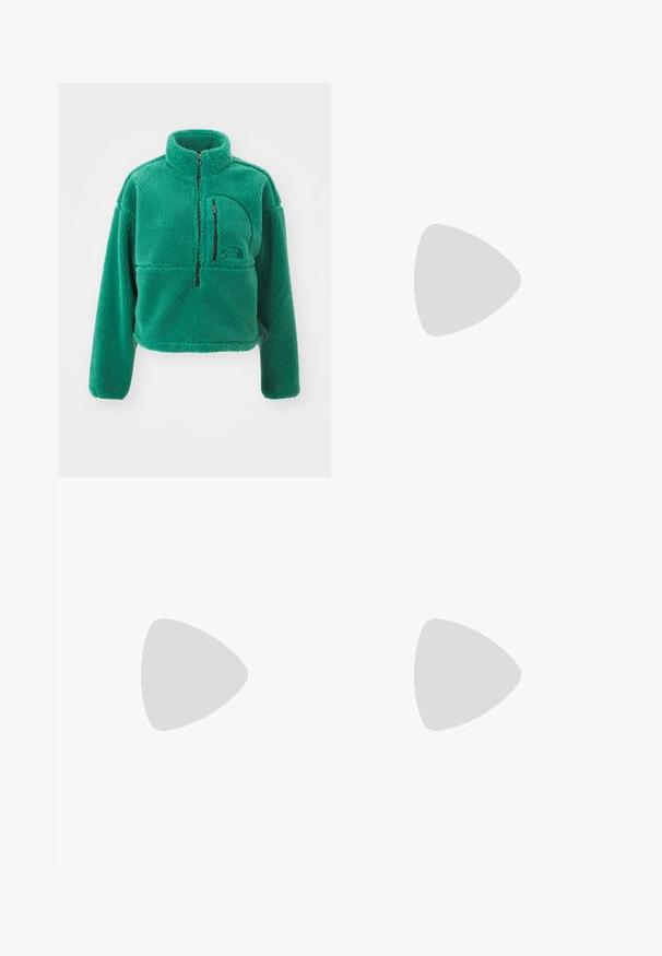 The North Face EXTREME - Pulover iz flisa - evergreen/black; Odrezan rebrast top v temno modri barvi, z visokim ovratnikom in subtilnim logotipom Nike. Tkanina ima teksturiran in elastičen videz.; Beli cargo hlače iz denima, ki imajo sproščen kroj, stranske žepke in vidne šive. Enostavna sprednja stran z gumbom za zapiranje.; Bela športna obutev s čipkastimi in sintetičnimi prekrivalnimi materiali, z značilnim srebrnim Nike znakom, v paru z rebrastimi belimi nogavicami na modri površini.