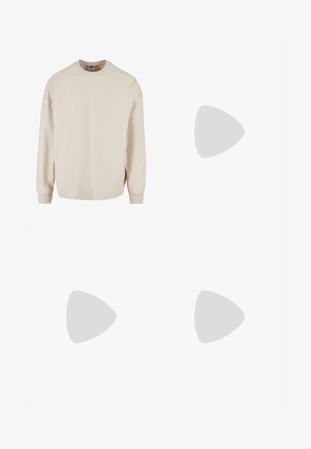 Bež pulover z dolgimi rokavi, s krožnim izrezom, ima spuščena ramena in ribane manšete. Mehka tekstura in sproščen kroj.; Oprijete jeans hlače iz izbledele sive denima, z obrabljenimi detajli na kolenih, v kombinaciji z belimi športnimi copati. Gladka tekstura, oblikovan slim fit dizajn.; Bela usnjena športna obutev s perforacijami, okroglo konico, ravnim podplatom in debelimi vezalkami, z vidnim logotipom smoosh in napisom "AIR" na peti.; Srebrna nerjaveča jeklena ura z modrim številčnico, kovinskimi kazalci ter oknom za datum na 3. uri. Vodoodporna do 50 metrov.