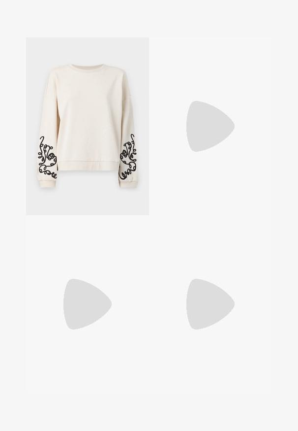 Kremowy sweatshirt z okrągłym dekoltem, opuszczonymi ramionami oraz czarnymi abstrakcyjnymi haftami na rękawach. Miękki, teksturowany materiał.; Jasnoniebieskie dżinsy w kształcie dzwonów, wykonane z denimu, z wysokim stanem, pięcioma kieszeniami i delikatnym gradientowym blaknięciem w kierunku dołu nogawki.; Jasnoszare sneakersy wykonane z zamszu i siateczki, z trzema białymi paskami, okrągłym noskiem i gumową podeszwą. Złoty akcent logo w pobliżu sznurowadeł.; Okulary przeciwsłoneczne w kształcie kocich oczu z czarno-pomarańczową oprawą w deseń żółwia, brązowymi soczewkami i eleganckimi, spiczastymi końcówkami. Posiadają minimalistyczne logo na zauszniku.