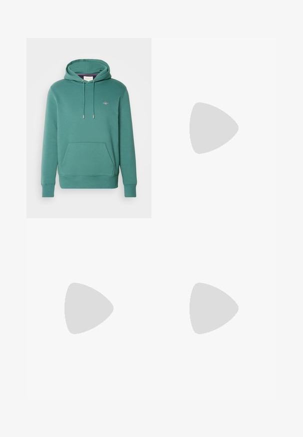 GANT REG SHIELD - Felpa con cappuccio - green; Camicia di velluto a coste verde oliva con maniche lunghe, chiusura a bottoni, due tasche sul petto e una toppa grafica di una montagna sulla tasca sinistra.; Jeans in denim blu con un design a gamba dritta, caratterizzati da una chiusura con bottone e zip, stile a cinque tasche e dettagli di cucitura minimal.; Scarpe sportive con tomaia in pelle bianca, punta in suede grigia e tre strisce nere. Presentano un logo blu sulla linguetta e una suola in gomma testurizzata.