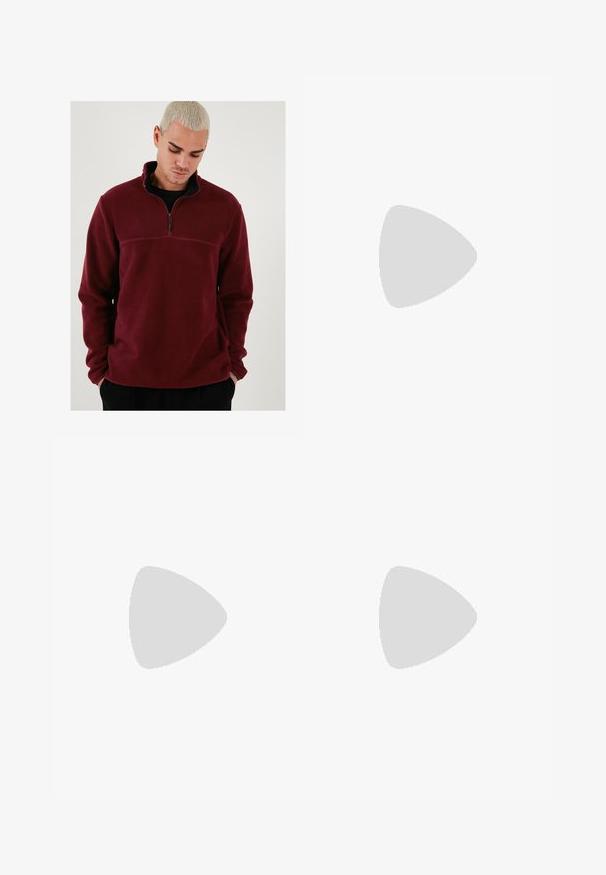 Burgundi színű fleece pulóver magas nyakkal, félig cipzárral és fekete kiegészítőkkel. Puha tapintású, hosszú ujjú, vízszintes varrással.; Fehér pamut póló rövid ujjal, kerek nyakú, laza szabású, és nincsenek látható logók vagy minták. Simább textúra és minimalista dizájn.; Magasan szabott, bővebb szabású farmernadrág fakó fekete denim anyagban. Öt zsebbel, övhurkokkal és tiszta, egyenes lábszár dizájnnal rendelkezik.; Szürke és fehér sportcipő, velúr és bőr felsőrésszel, kerek orral, lapos fűzőkkel és gumitalppal, amelyen rágógumi színű díszítés található.