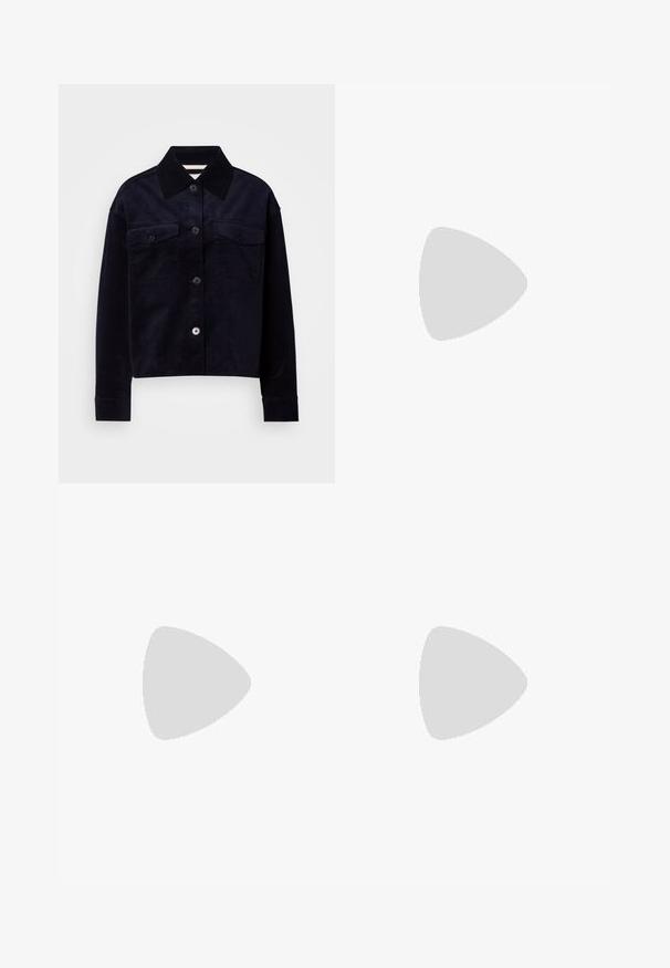 Dark navy corduroy jacket with large pointed collar, button front, and two flap chest pockets with buttons.; White wide-leg trousers made of denim, featuring a drawstring waist, front pockets, and a button closure. Smooth texture and plain design.; Black leather ankle boot with a chunky heel, elastic side panels, and a pull tab at the back. Textured sole for added grip.; Black handbag with structured shape, smooth texture, and a metallic clasp. Paired with wide black pants and open-toe sandals on wooden floor.