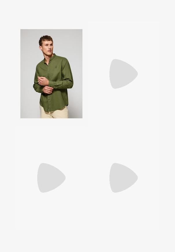 Green long-sleeve shirt with a button-down collar, featuring a subtle texture and a small logo on the chest. Smooth cotton fabric.; Beige trousers with a straight cut, featuring a single black button, belt loops, and side pockets. Smooth fabric texture and minimal design.; Brown suede loafer with a rounded toe, featuring a decorative strap across the upper, and a low leather heel. Smooth texture and minimal design.; Black sunglasses with a square frame, featuring dark lenses. Accented with small gold dots and a gold logo on the temple. Smooth texture.